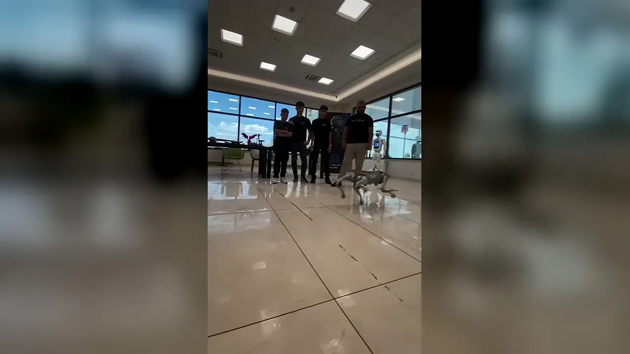 CEZERİ ROBOTECH merkezinde dört ayaklı robot köpeğin öğrencilerin ve insansı robotun önünde yürüyüşü