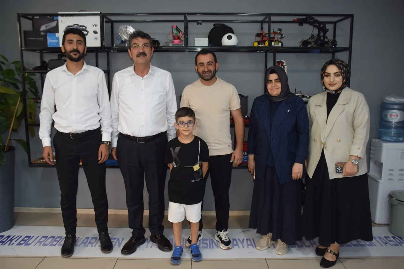 Batman Milletvekili Ferhat Nasıroğlu, CEZERİ ROBOTECH ekibi ve bir öğrenciyle atölyedeki proje rafının önünde