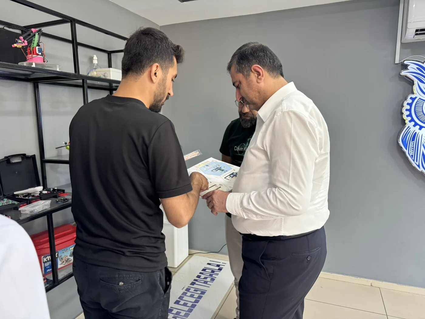 Batman Milletvekili Serkan Ramanlı, CEZERİ ROBOTECH atölyesinde eğitmenden robotik eğitim setini teslim alıyor