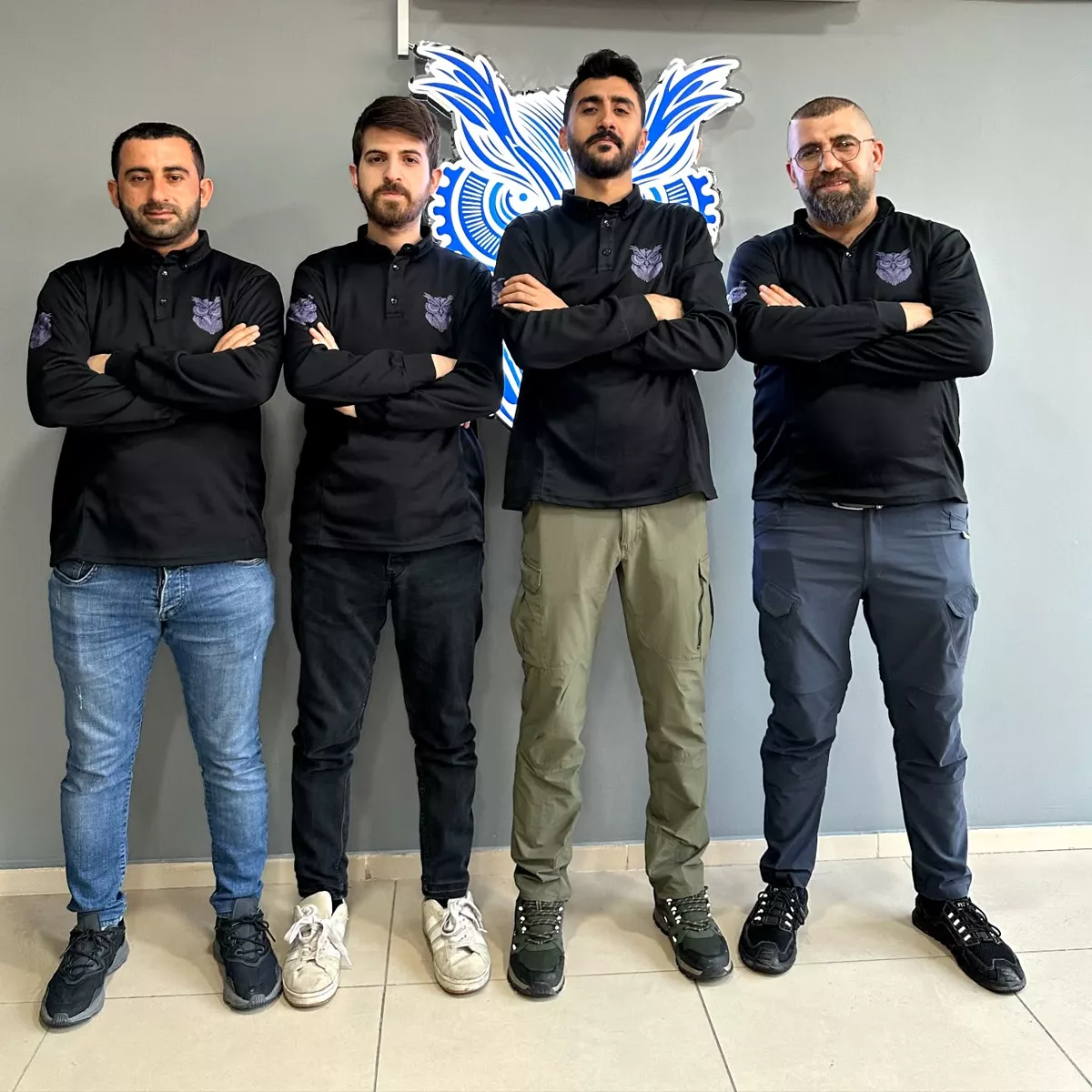 CEZERİ ROBOTECH Batman eğitmen kadrosu, kurumun robotik baykuş amblemi önünde